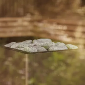 Saunaofen mit hellen Steinen hinter Glas